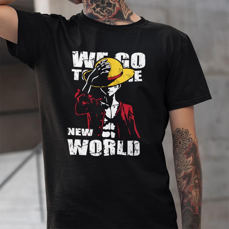 μαύρο μπλουζάκι με γραφικό του Luffy να κρατάει το ψάθινο καπέλο του, σε κόκκινο και κίτρινο χρώμα, με το κείμενο "WE GO TO THE NEW WORLD" σε vintage, φθαρμένη γραμματοσειρά